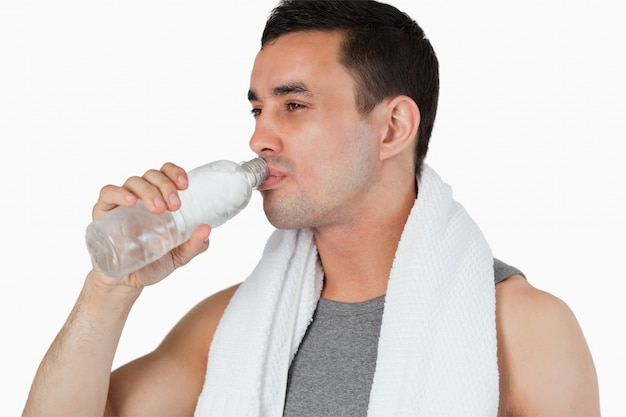 Giovane che prende una sorsata di acqua dopo l&#39;allenamento