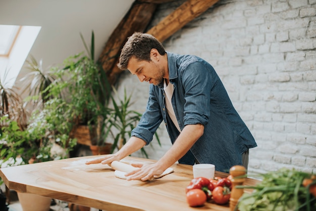 Giovane che prepara pasta per il pane fatto in casa in cucina