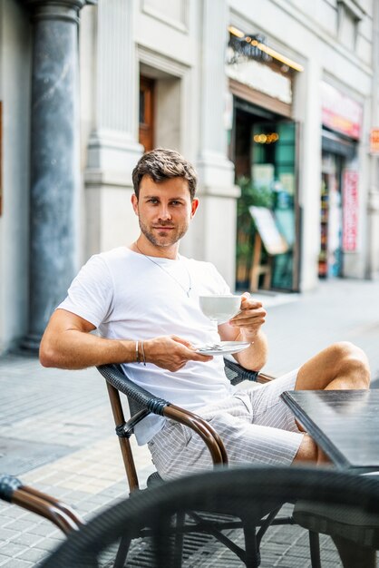 Giovane che riposa in un caffè di strada