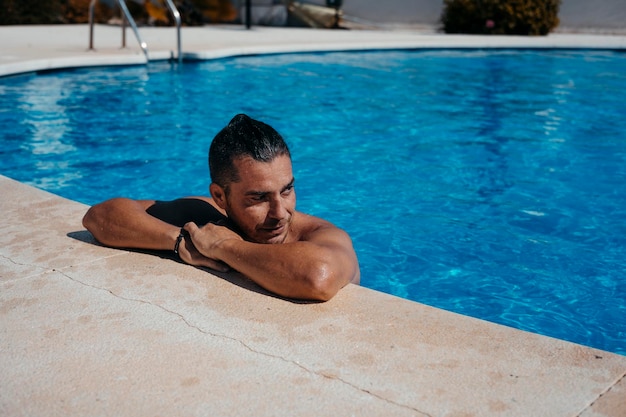 Giovane che si distende in piscina Foto di alta qualità