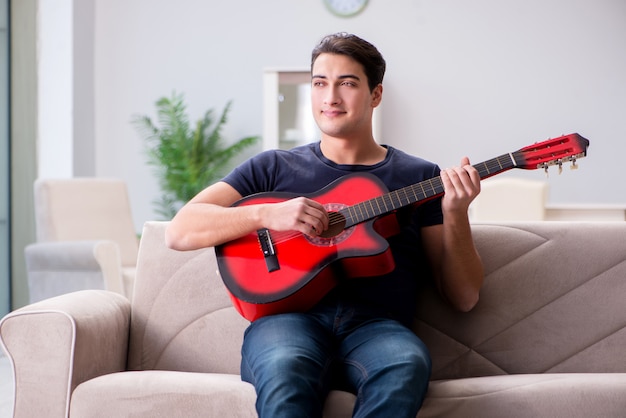 Giovane che si esercita nel suonare la chitarra a casa