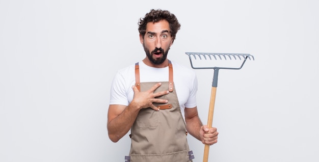 Giovane che si sente scioccato, stupito e sorpreso, con la mano sul petto e la bocca aperta, dicendo chi, io?