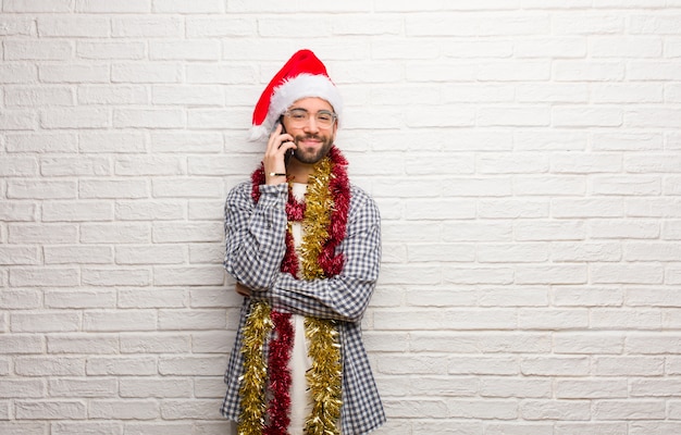 Giovane che si siede con i regali che celebrano le armi dell&#39;incrocio di natale, sorridenti e rilassate