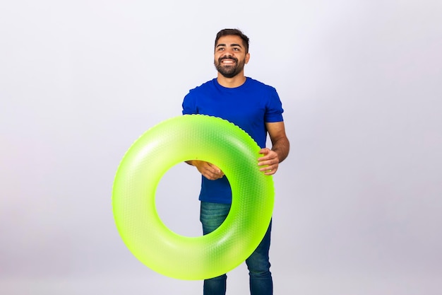 Giovane che tiene un carro verde con la faccia felice in piedi e sorridendo con un sorriso sicuro che mostra i denti concetto di vacanza e divertimento