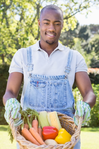 Giovane che tiene un cestino delle verdure appena raccolte