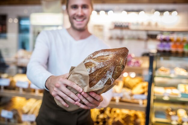 Giovane che tiene un pane appena sfornato