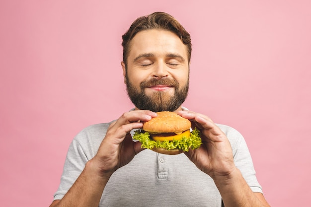 Giovane che tiene un pezzo di hamburger