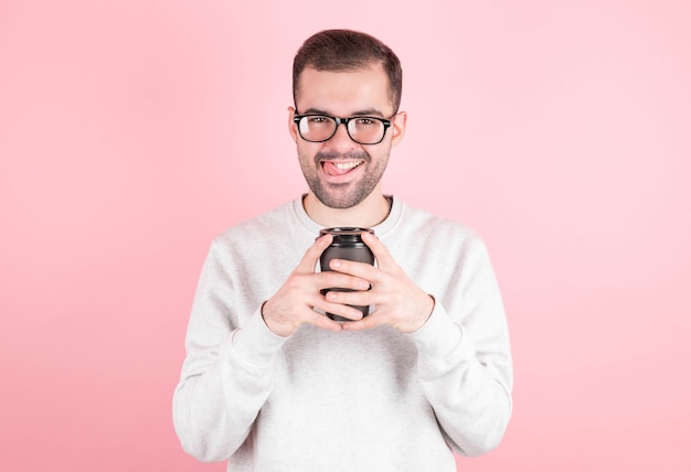 Giovane che tiene una tazza di caffè che osserva in su. L'uomo beve il sogno del caffè. Rilassarsi e pensare a una tazza di caffè.