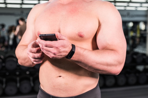 Giovane che utilizza il braccialetto di forma fisica durante l'allenamento sportivo in palestra