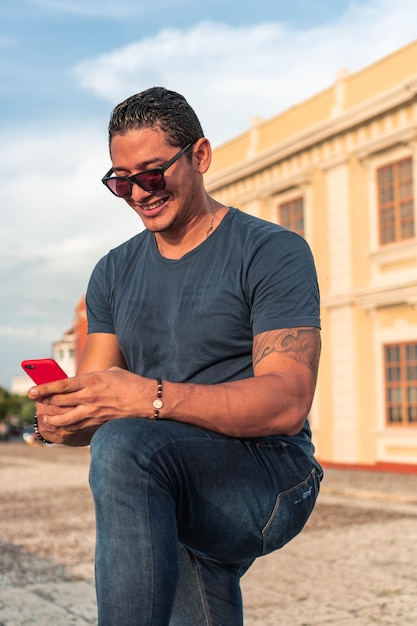 Giovane che utilizza un telefono cellulare all'aperto.