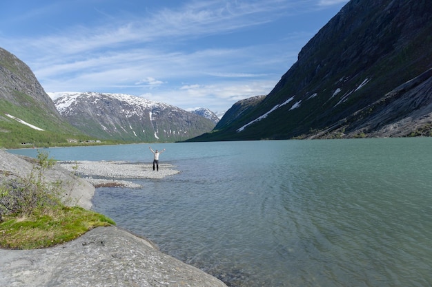 Giovane che visita il lago glaciale Nigardsbreen in Norvegia