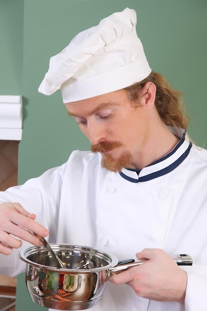 Giovane Chef che assaggia il cibo con un cucchiaio