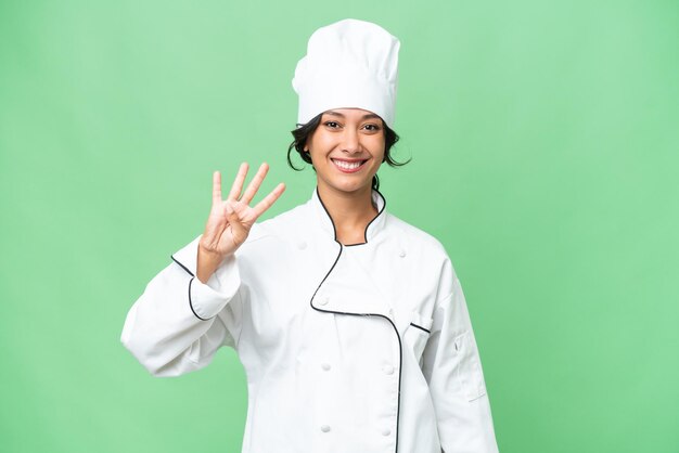 Giovane chef donna argentina su sfondo isolato felice e contando quattro con le dita