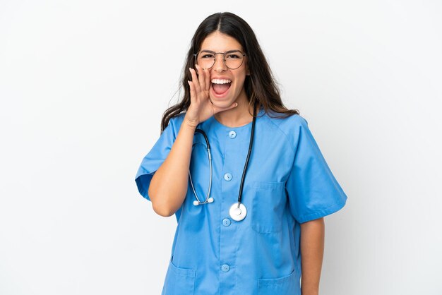 Giovane chirurgo medico donna caucasica isolata su sfondo bianco che grida con la bocca spalancata