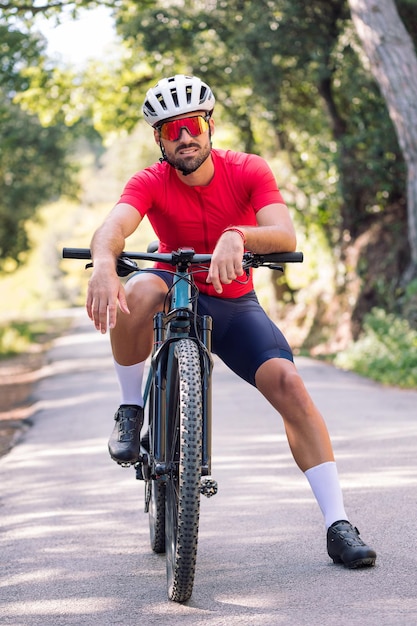 Giovane ciclista che riposa sulla sua bici dopo l'allenamento