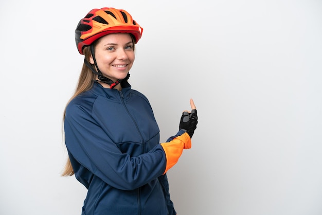 Giovane ciclista donna lituana isolata su sfondo bianco che punta indietro