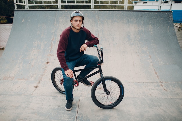 Giovane ciclista sportivo professionista con la bici allo skatepark