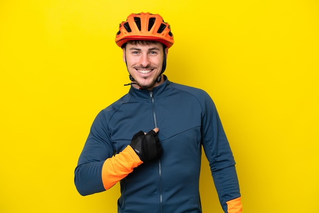 Giovane ciclista uomo caucasico isolato su sfondo giallo con espressione facciale a sorpresa