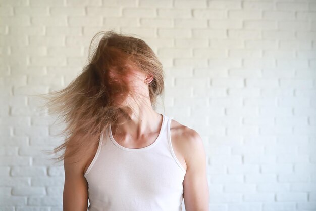 Giovane con i capelli lunghi che agita la testa