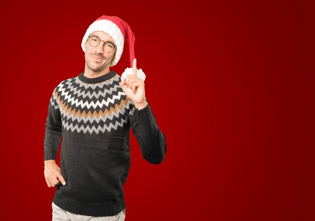 Giovane con il cappello di Natale che gesturing