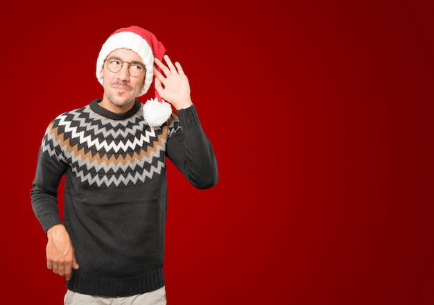 Giovane con il cappello di Natale che gesturing