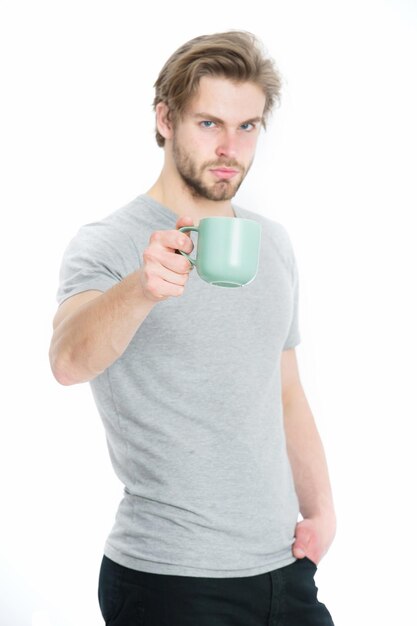 Giovane con la tazza che beve caffè o tè in camicia di moda isolata su fondo bianco