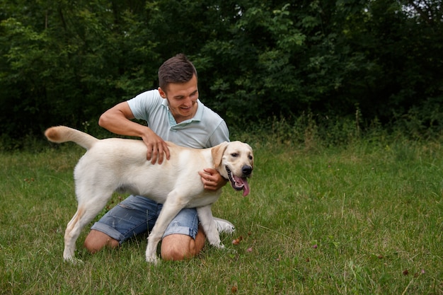 Giovane con labrador felice nel parco