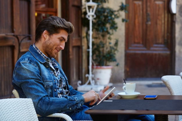 Giovane con tablet pc touch in un caffè