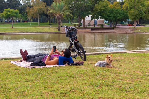 Giovane con un cane che riposa nel parco.