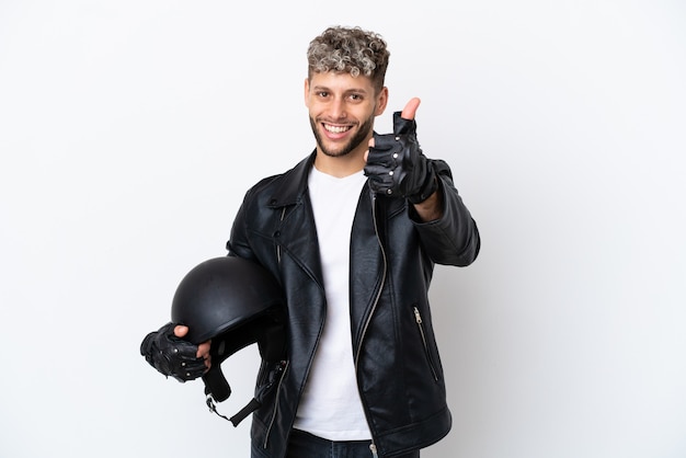 Giovane con un casco da motociclista isolato su sfondo bianco con il pollice in alto perché è successo qualcosa di buono