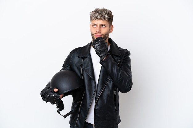 Giovane con un casco da motociclista isolato su sfondo bianco e alzando lo sguardo