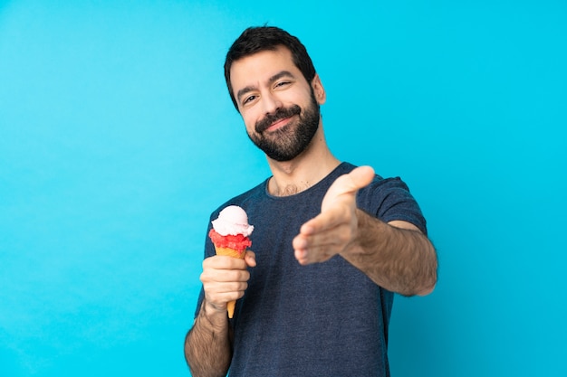 Giovane con un gelato della cornetta sopra le mani stringere blu per la chiusura molto