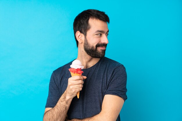 Giovane con un gelato di cornetta con le braccia incrociate e felice