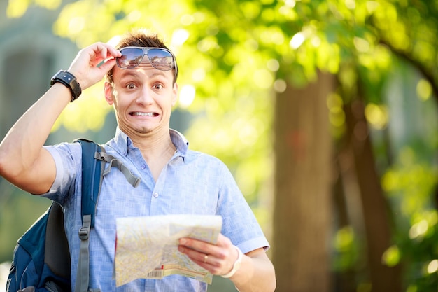 Giovane con una mappa all'aperto