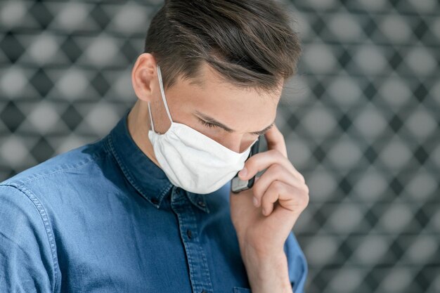 Giovane con una maschera protettiva che guarda la telecamera