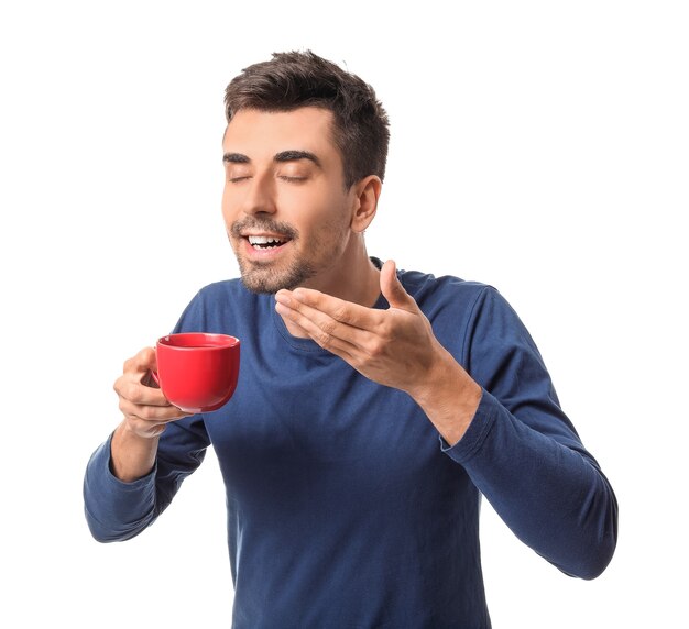 Giovane con una tazza di caffè caldo su sfondo bianco