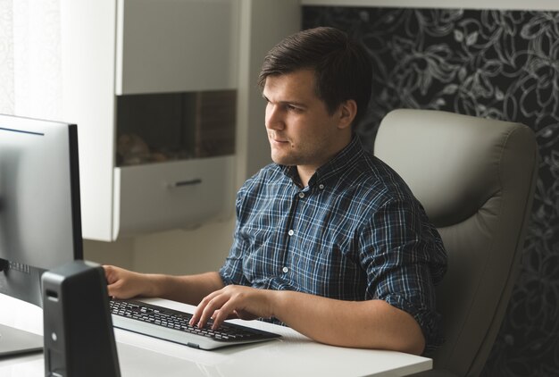 Giovane concentrato che lavora al computer