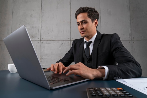 Giovane concentrato che utilizza il computer portatile in ufficio