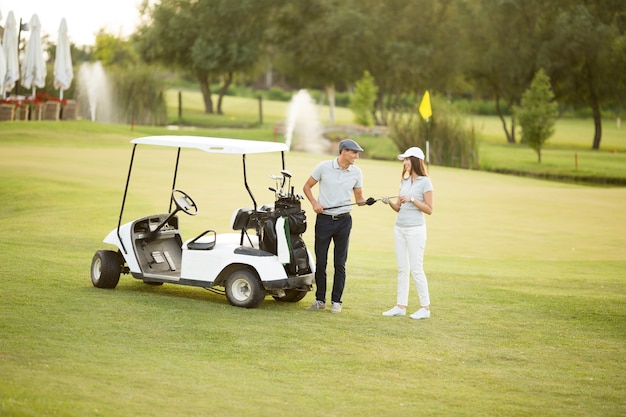 Giovane coppia al carrello da golf