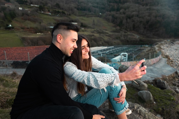 Giovane coppia caucasica che scatta una foto in un paesaggio sconosciuto