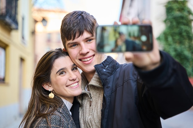 giovane coppia che fa un selfie con il loro smartphone in città