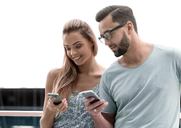 Giovane coppia che legge un messaggio di testo sullo smartphone