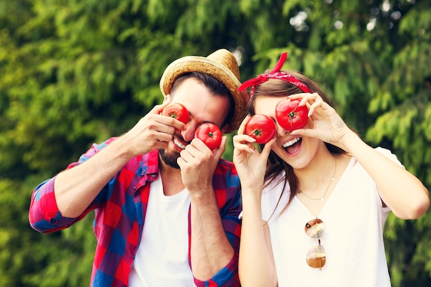 giovane coppia che pianta pomodori biologici