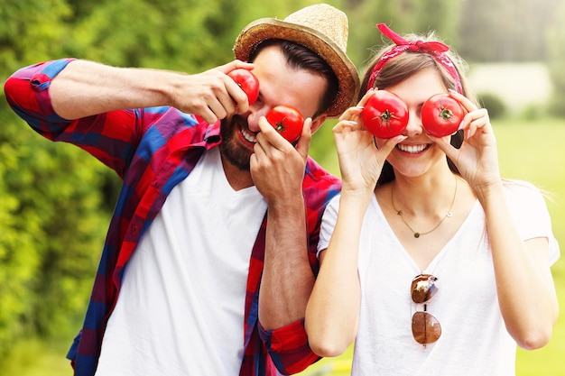giovane coppia che pianta pomodori biologici