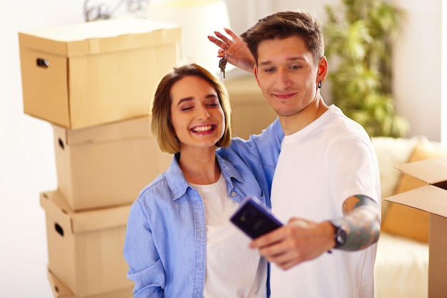 Giovane coppia che scatta selfie con il suo smartphone nella loro nuova casa