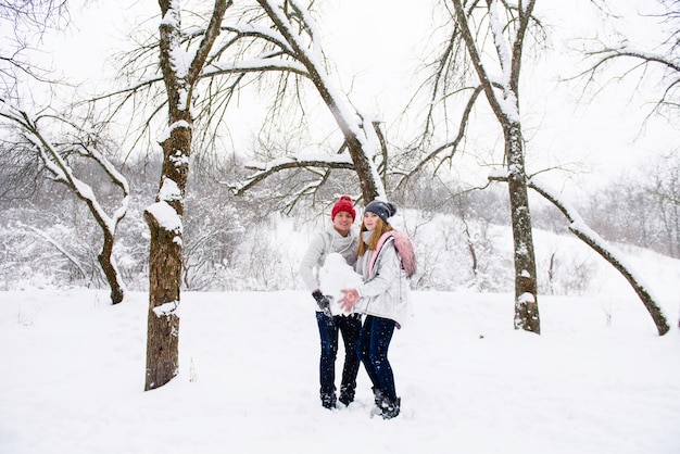 Giovane coppia con palla di neve