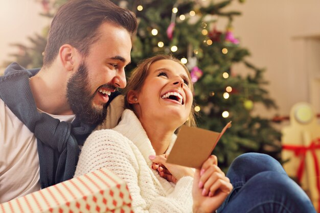 giovane coppia con un regalo sull'albero di Natale Christmas