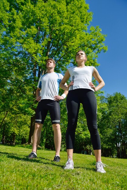 giovane coppia di salute che fa esercizio di stretching rilassante e riscaldarsi dopo aver fatto jogging e corsa nel parco