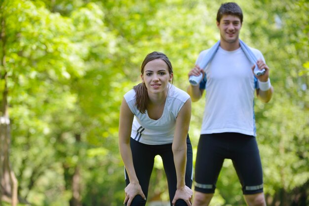 giovane coppia di salute che fa esercizio di stretching rilassante e riscaldarsi dopo aver fatto jogging e corsa nel parco