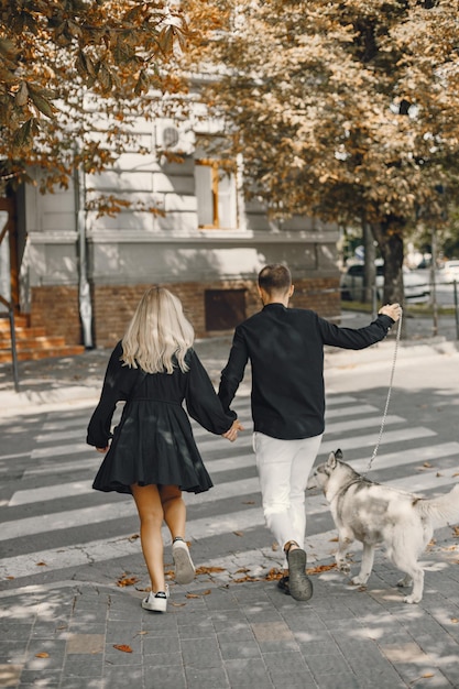 Giovane coppia elegante che cammina con il cane in strada